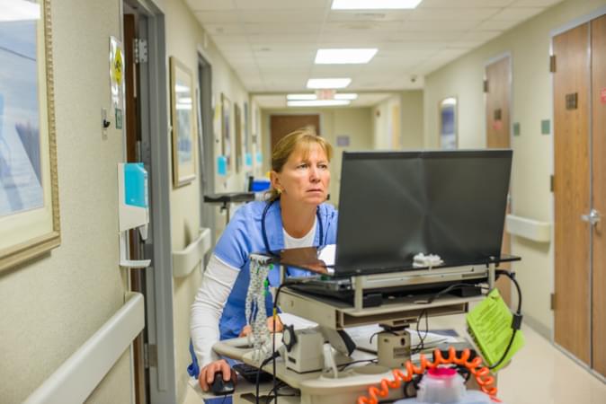 Shows a nurse operating healthcare software